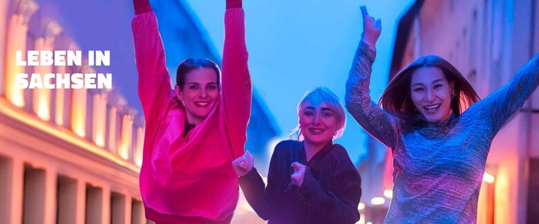 3 junge Menschen vor Stadtkulisse