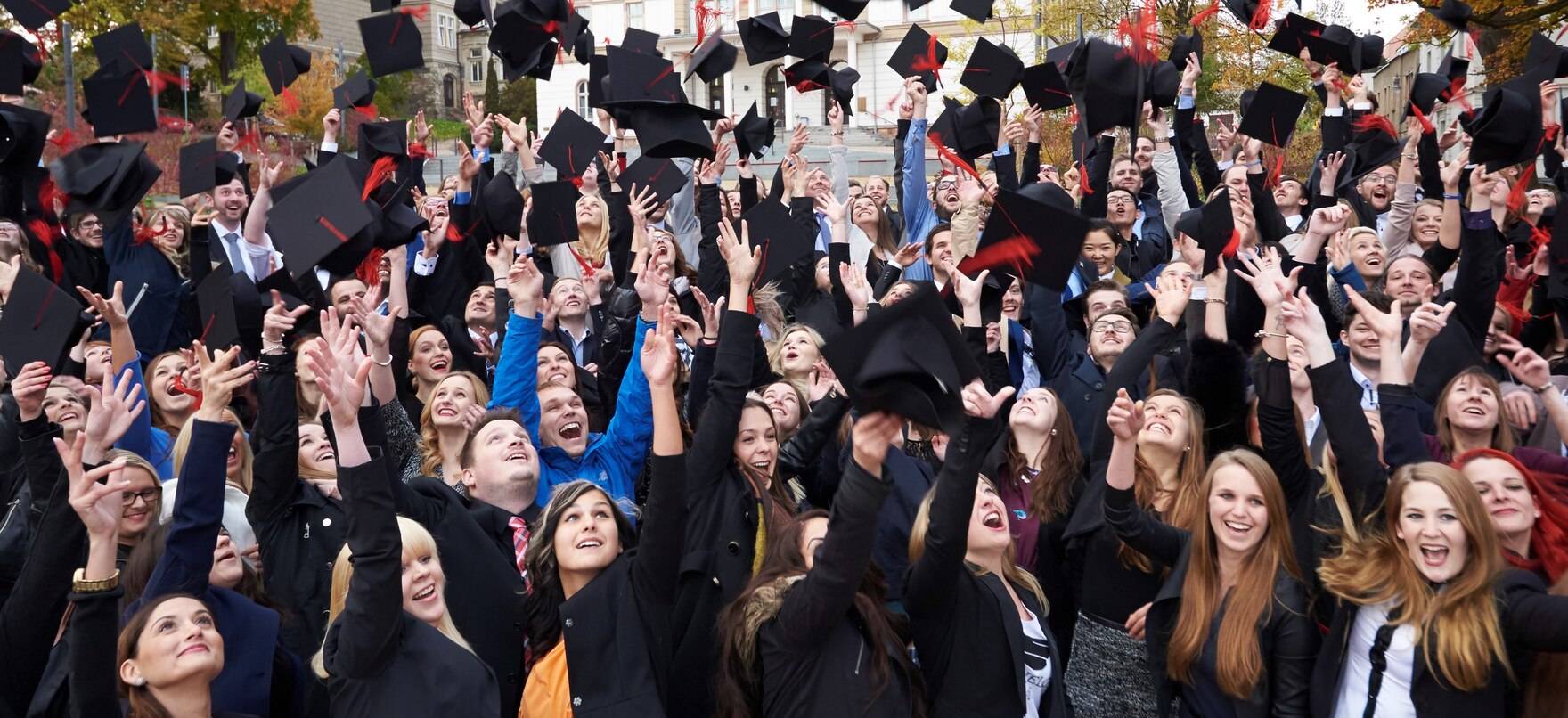 Studenten werfen ihre Hüte in die Höhe